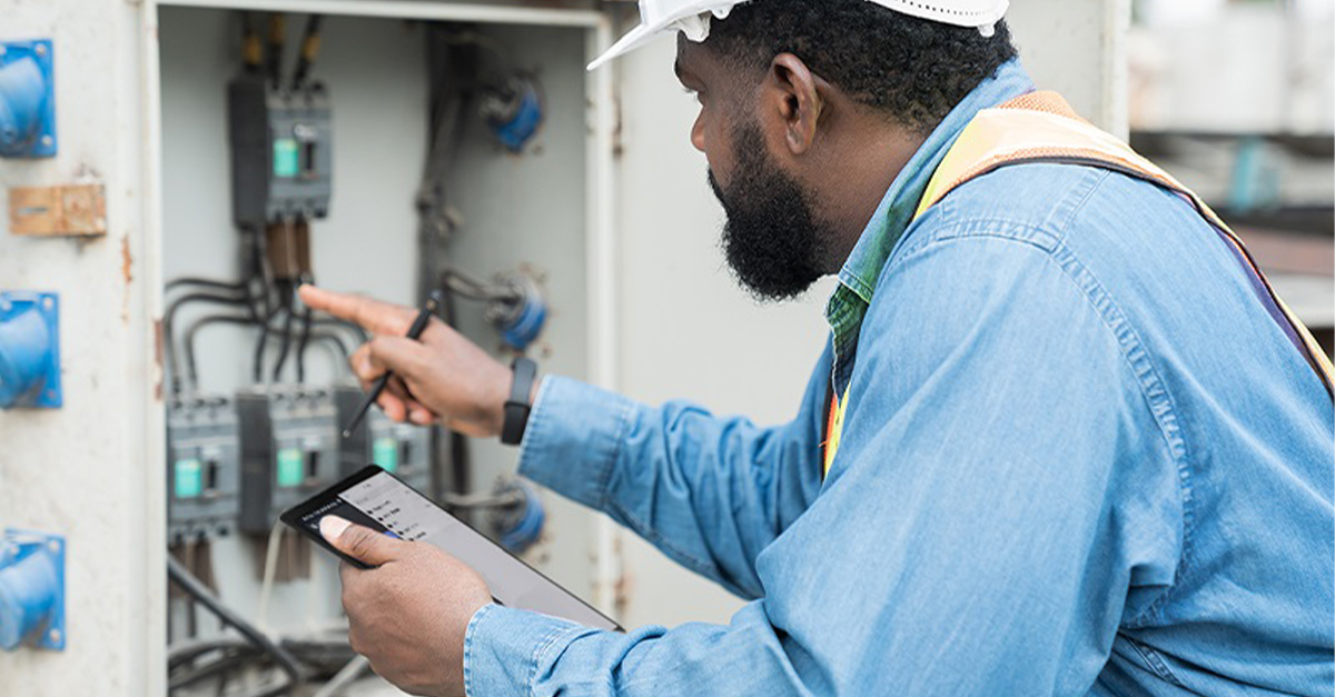 A subcontractor in the electrical industry uses a tablet in the field to manage tasks and record work completed.