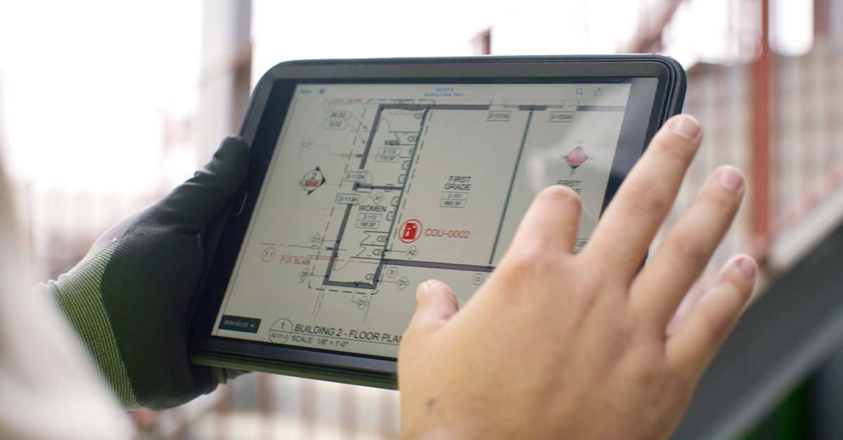 A field employee accesses the latest digital plans in Fieldwire on a tablet, ensuring better communication between trades.