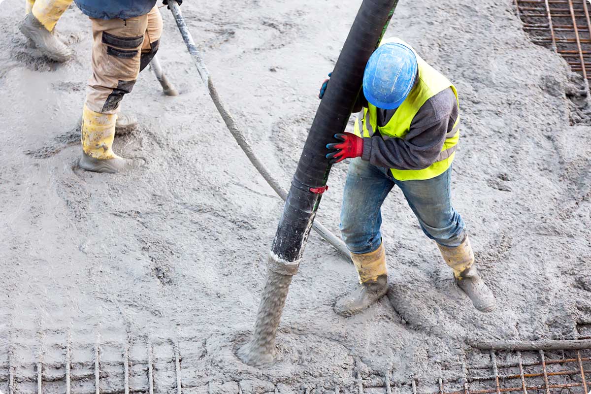 Concrete subcontractor worker pouring concrete on construction jobsite