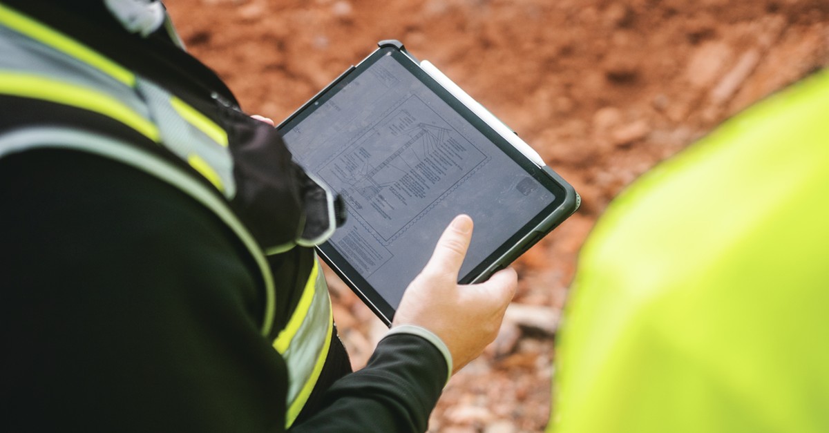 Construction worker using the Fieldwire app on a jobsite.