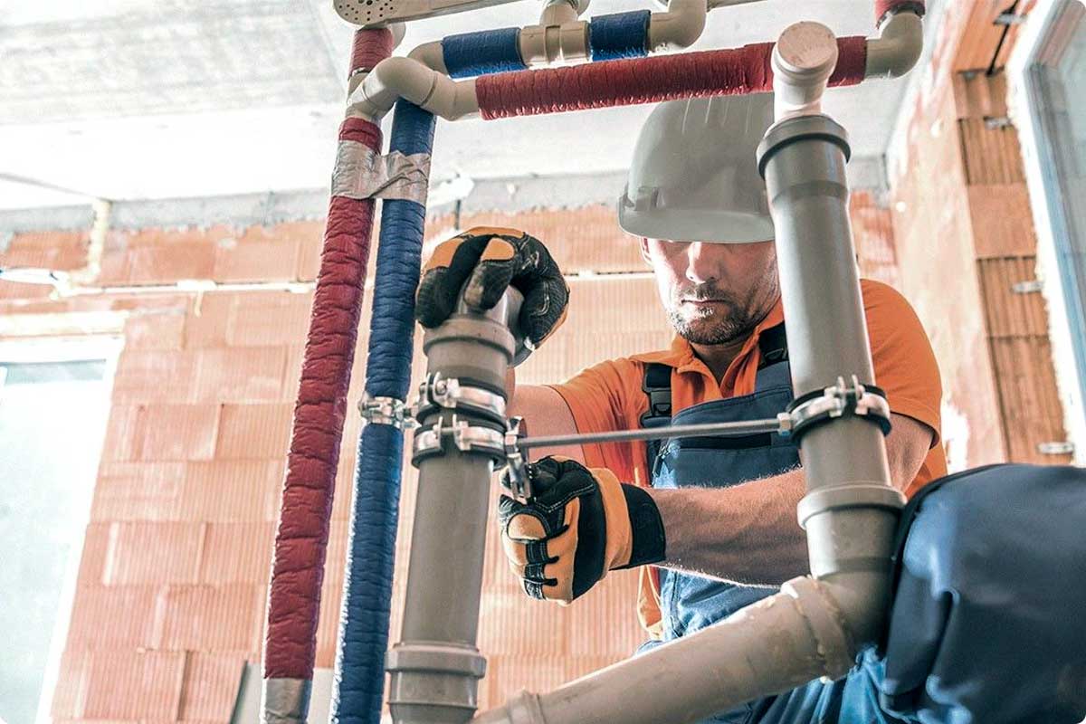 Plumber subcontractor worker fixing pipe on construction jobsite